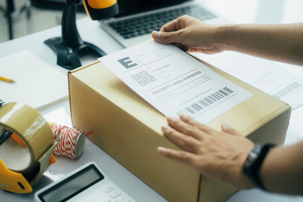 Young business owner putting shipping label on parcel.. Mail-In Repair vs Local Walk-In Service